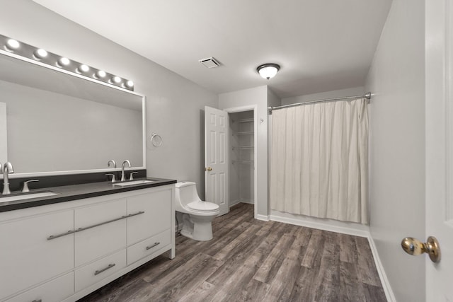 full bathroom featuring wood-type flooring, vanity, toilet, and shower / bathtub combination with curtain