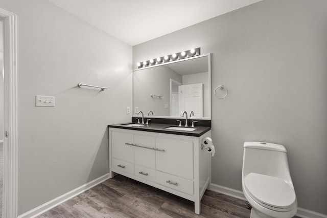 bathroom featuring hardwood / wood-style flooring, vanity, and toilet