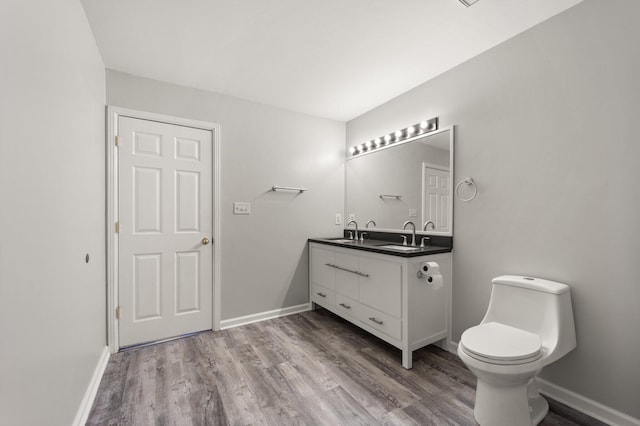 bathroom featuring toilet, vanity, and hardwood / wood-style flooring