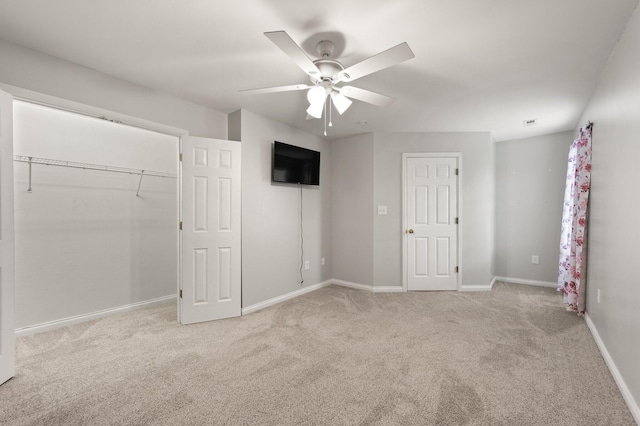 unfurnished bedroom with ceiling fan, a closet, and light colored carpet