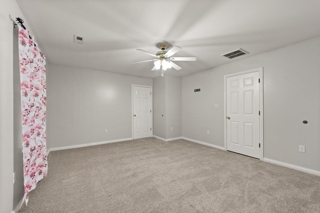 unfurnished room featuring ceiling fan and carpet