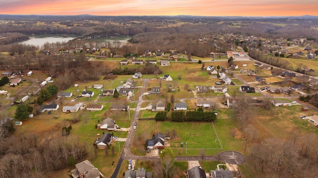 aerial view at dusk featuring a water view