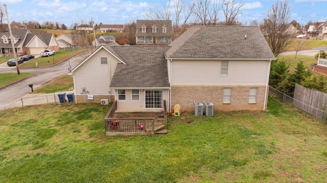 back of house with a lawn, a wooden deck, and central air condition unit