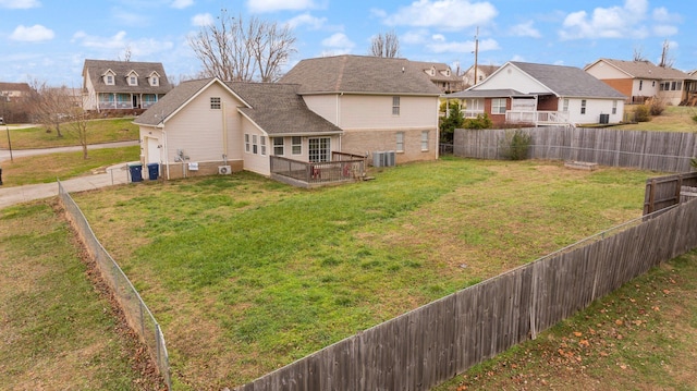 rear view of property featuring a lawn, central air condition unit, and a deck