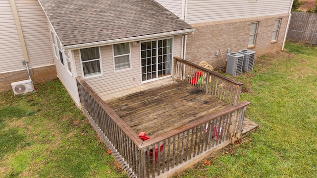 wooden deck with a lawn, ac unit, and central air condition unit