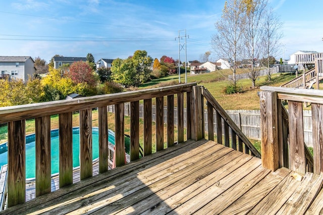 wooden deck with a fenced in pool