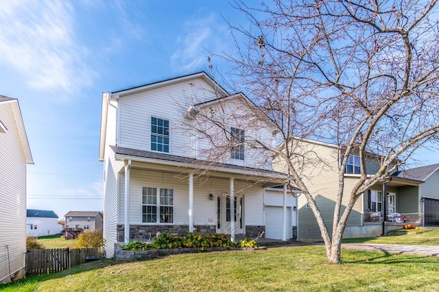 view of front of property featuring a front yard, a porch, and a garage