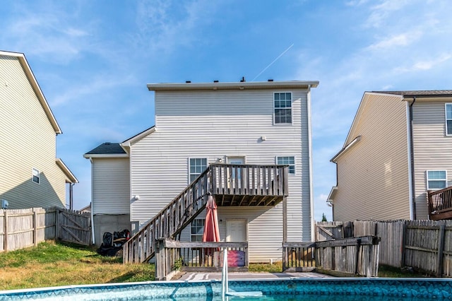 rear view of house with a fenced in pool