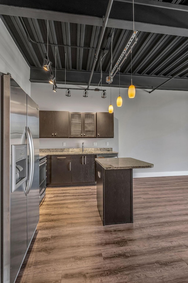 kitchen featuring dark brown cabinetry, hardwood / wood-style floors, stainless steel appliances, and track lighting