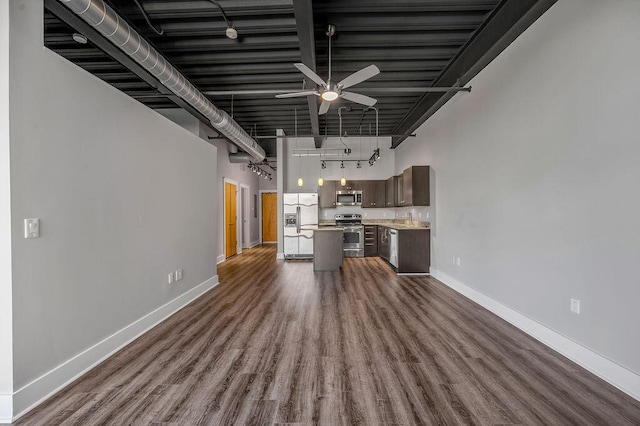 kitchen with dark wood-type flooring, rail lighting, ceiling fan, dark brown cabinets, and stainless steel appliances