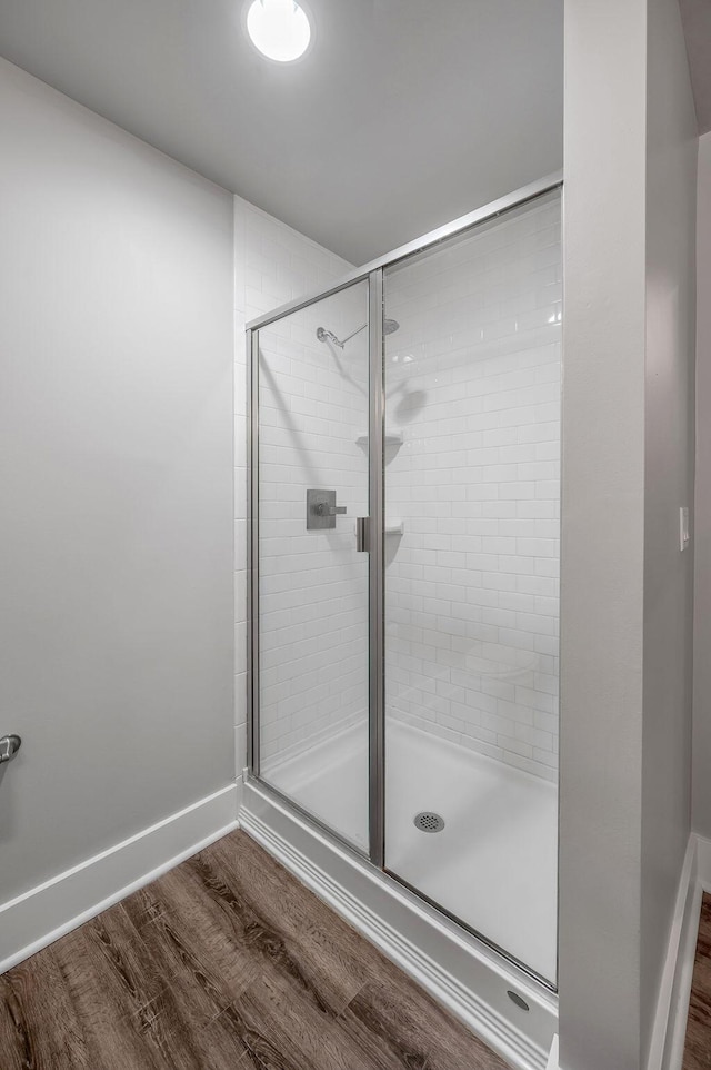 bathroom with hardwood / wood-style floors and a shower with door