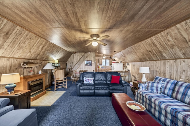 carpeted living room featuring vaulted ceiling, ceiling fan, wood walls, and wood ceiling