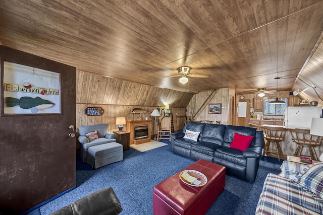 carpeted living room with lofted ceiling, wooden walls, ceiling fan, a fireplace, and wood ceiling