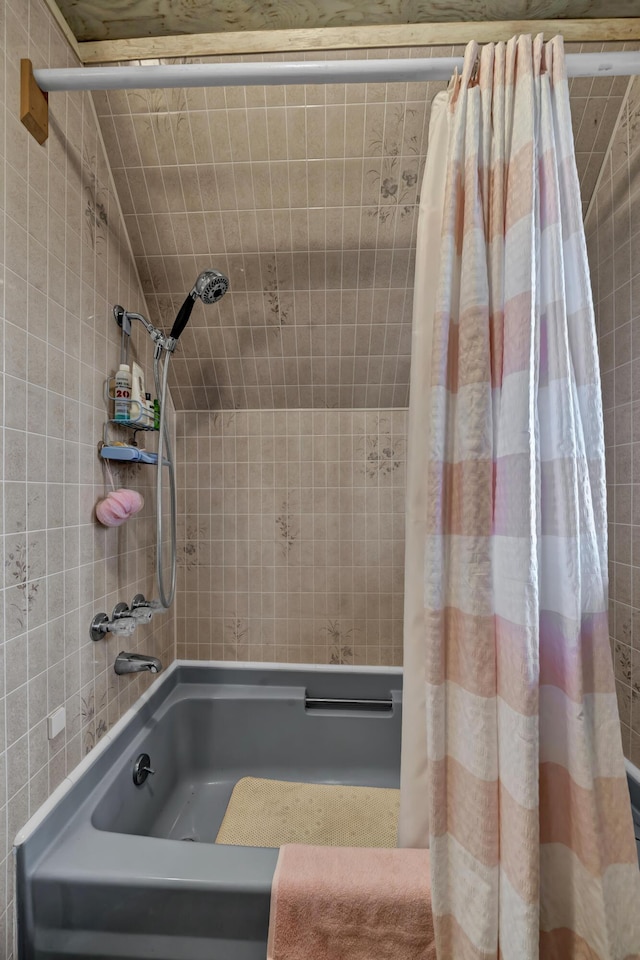 bathroom with shower / bath combo and lofted ceiling