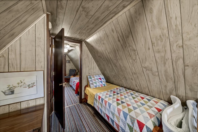 bedroom with wooden ceiling, wooden walls, and vaulted ceiling