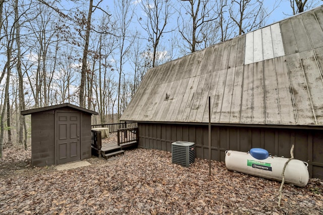 exterior space with a storage unit, central AC unit, and a deck