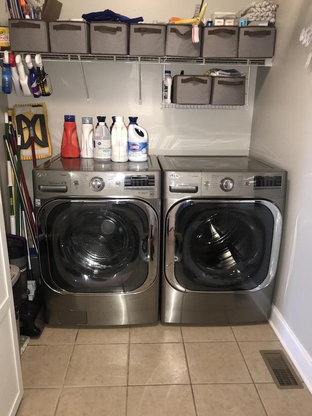 laundry area featuring separate washer and dryer and light tile patterned floors