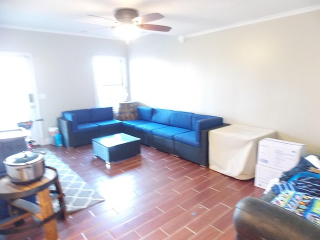 living room with dark wood-type flooring, ceiling fan, and ornamental molding