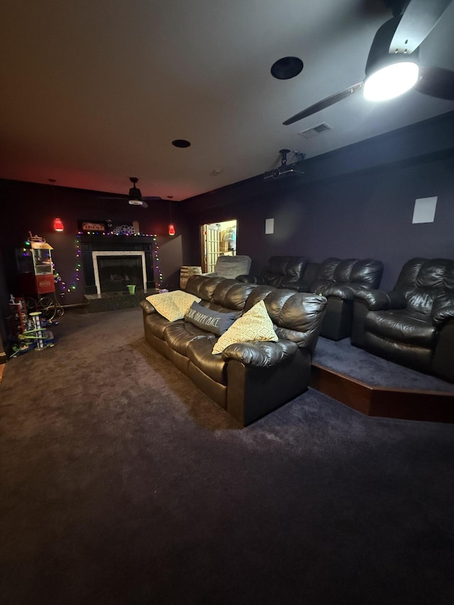 carpeted home theater room with a fireplace