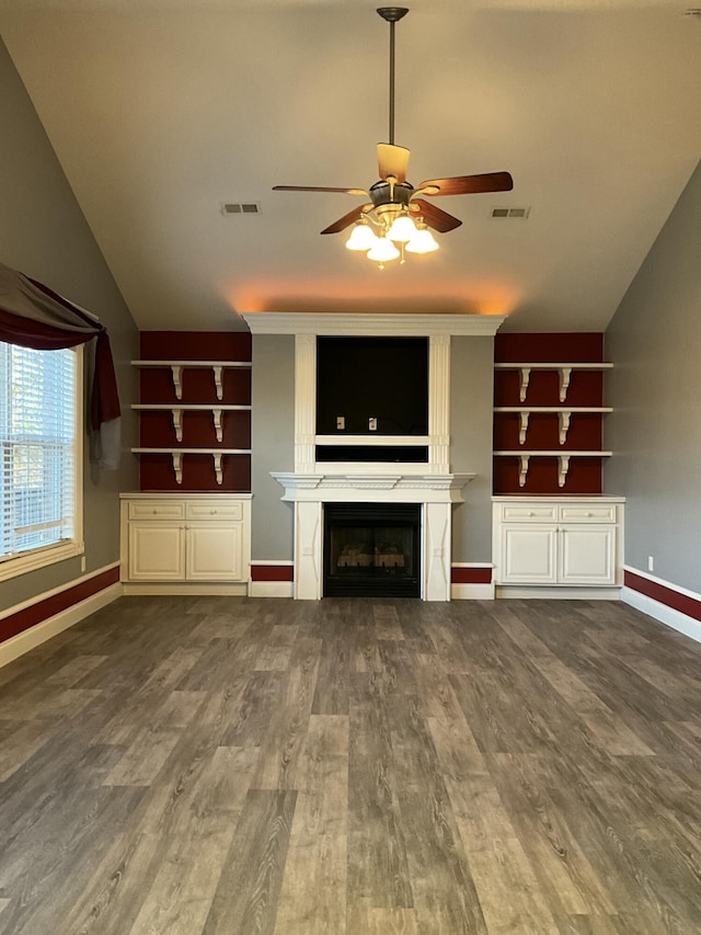 unfurnished living room with built in shelves, ceiling fan, lofted ceiling, and hardwood / wood-style floors