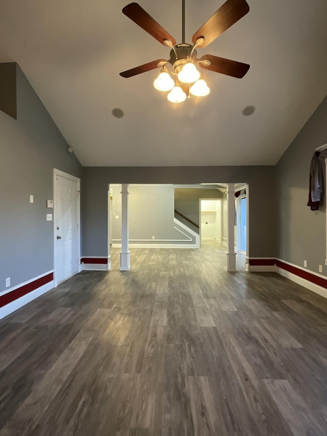 unfurnished living room with dark hardwood / wood-style flooring, vaulted ceiling, and decorative columns