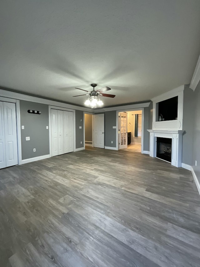 unfurnished living room featuring hardwood / wood-style flooring, ceiling fan, crown molding, and a textured ceiling