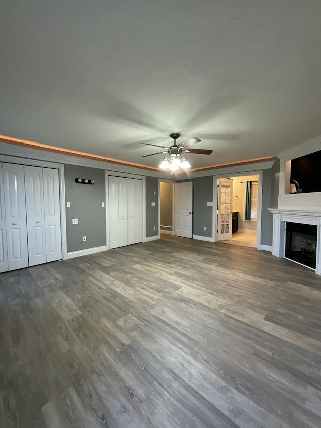 unfurnished living room with hardwood / wood-style flooring, ornamental molding, and ceiling fan