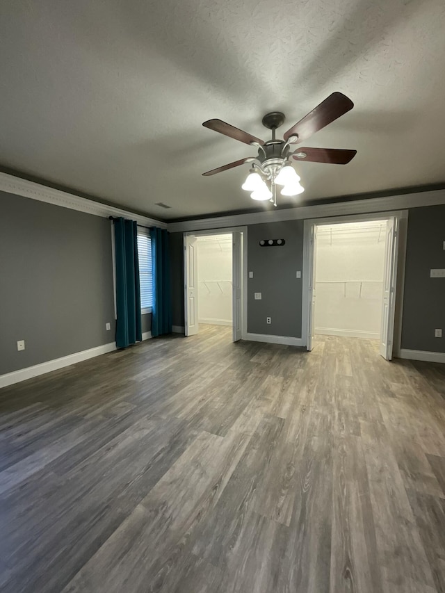 interior space with hardwood / wood-style floors, ornamental molding, and a textured ceiling