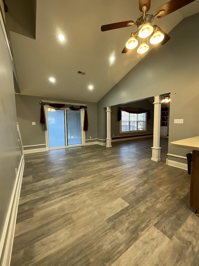 unfurnished living room featuring dark wood-type flooring, high vaulted ceiling, ceiling fan, and ornate columns