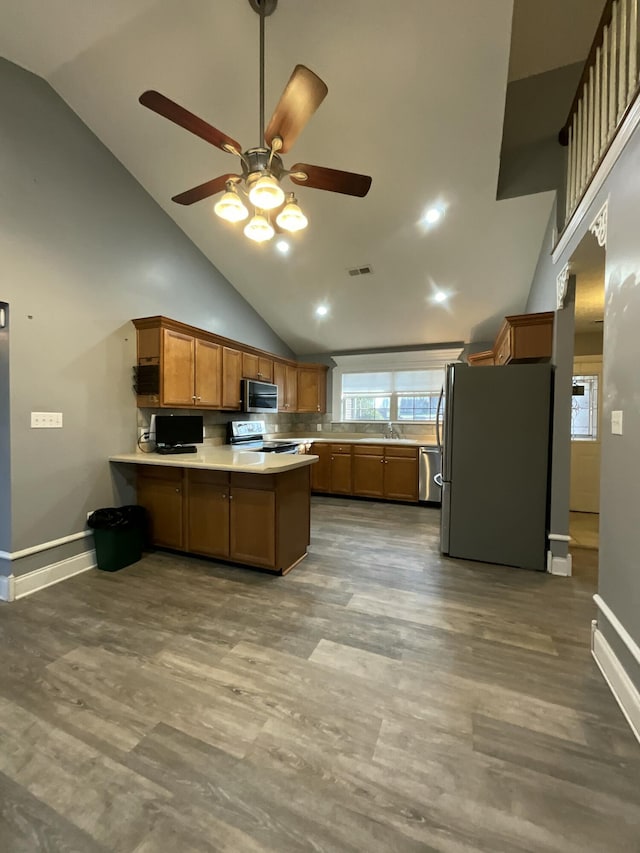 kitchen featuring appliances with stainless steel finishes, kitchen peninsula, and hardwood / wood-style floors