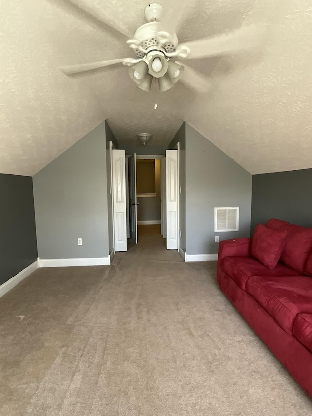 bonus room with ceiling fan, lofted ceiling, carpet floors, and a textured ceiling