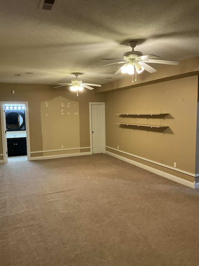 carpeted empty room with ceiling fan and a textured ceiling