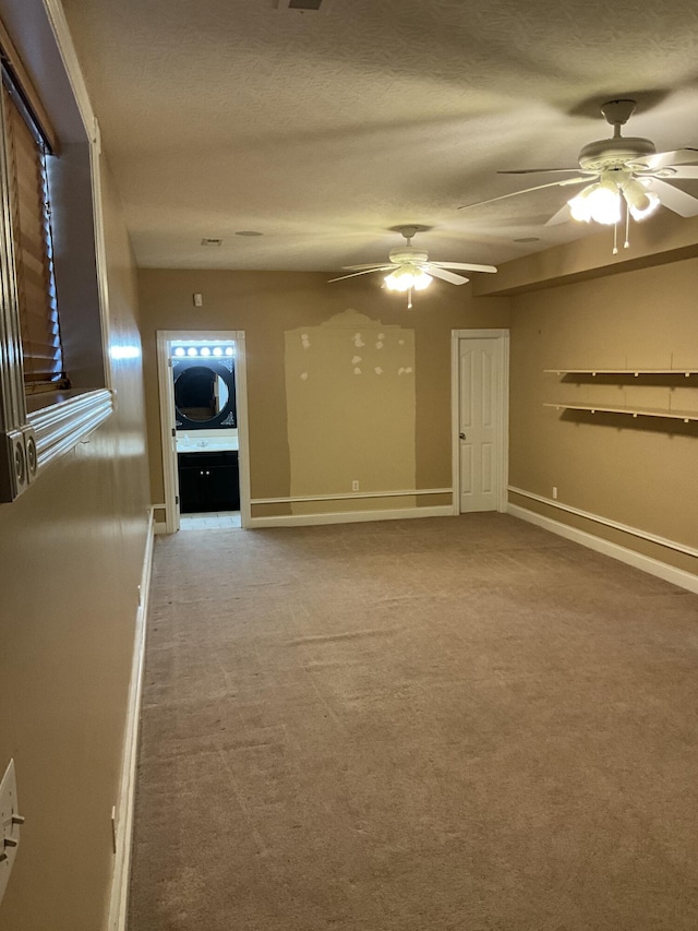 spare room with ceiling fan, light colored carpet, and a textured ceiling