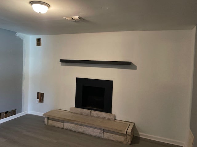 room details featuring hardwood / wood-style floors and a stone fireplace