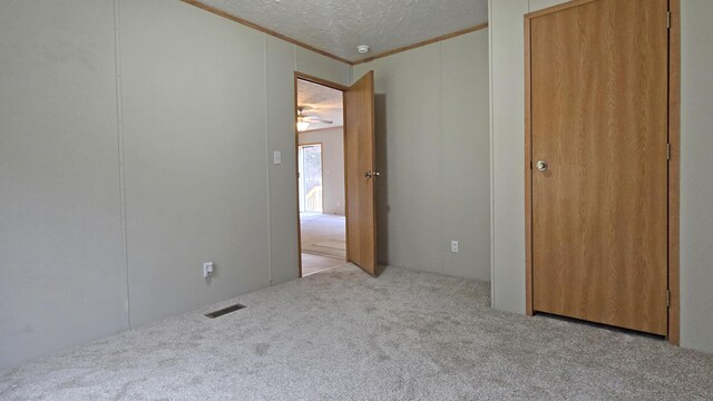 unfurnished room with a textured ceiling and light colored carpet