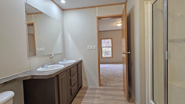 bathroom featuring a textured ceiling, an enclosed shower, toilet, vanity, and hardwood / wood-style flooring