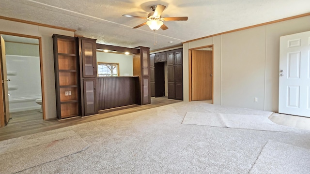 empty room with ceiling fan, ornamental molding, a textured ceiling, and light carpet