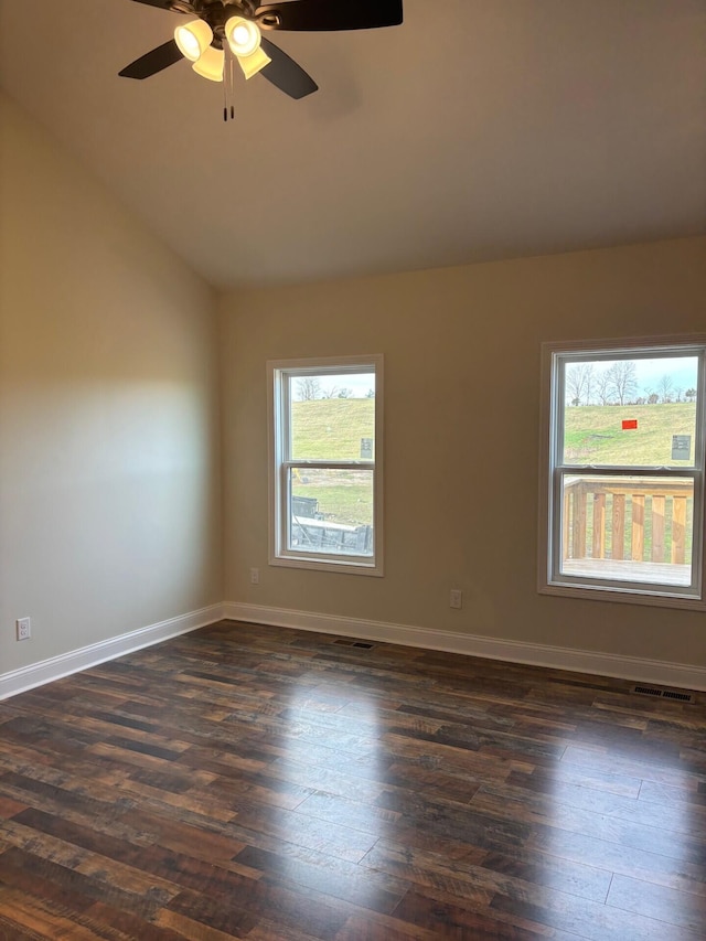 unfurnished room featuring dark wood-type flooring, vaulted ceiling, ceiling fan, and a healthy amount of sunlight