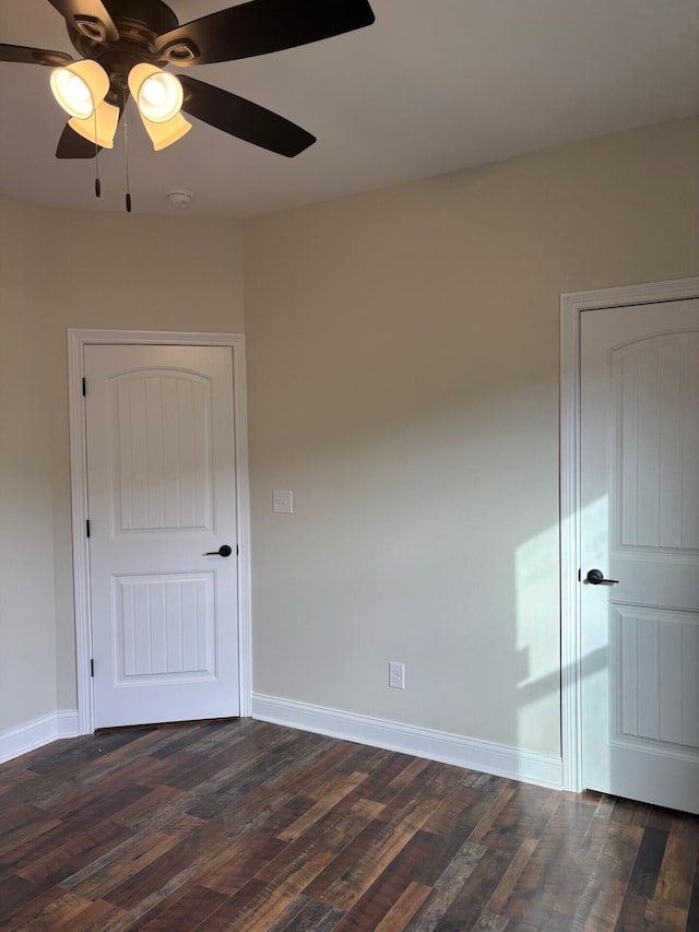 unfurnished room with ceiling fan and dark wood-type flooring