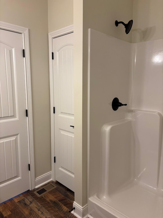 bathroom with hardwood / wood-style flooring and a shower