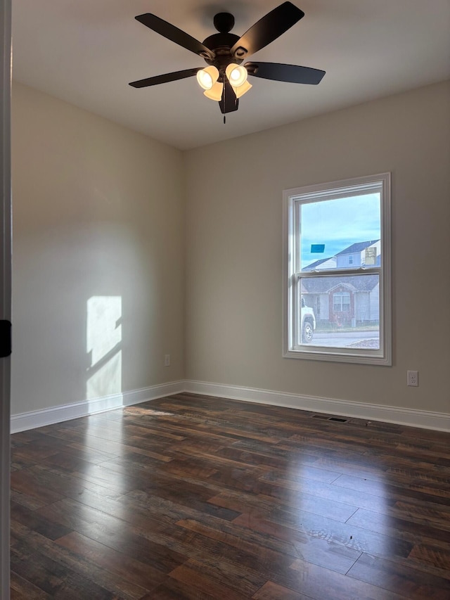 spare room with ceiling fan and dark wood-type flooring