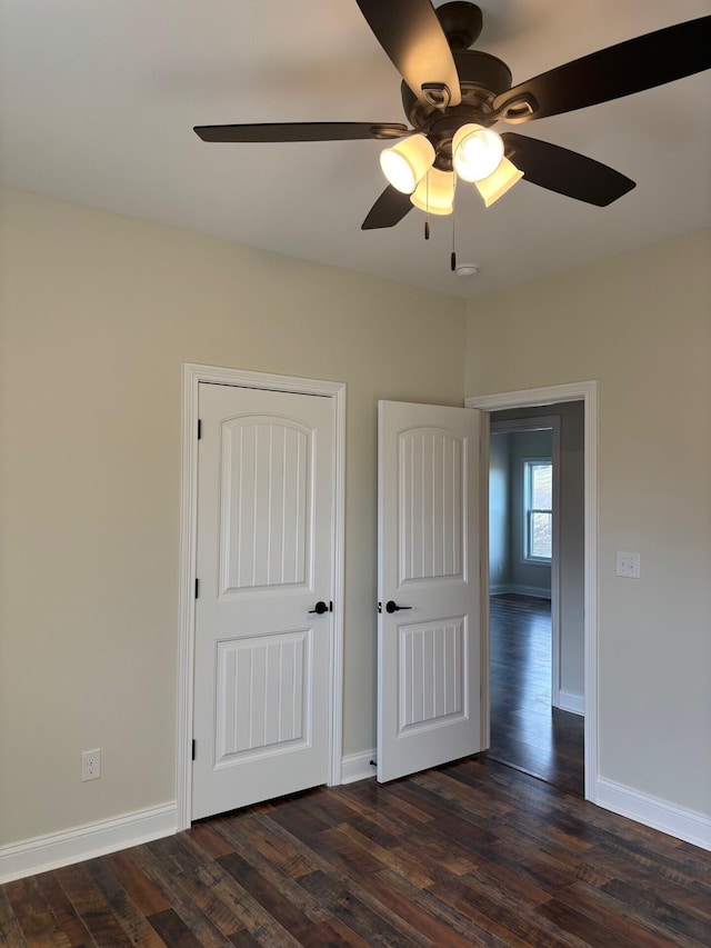 unfurnished bedroom featuring dark hardwood / wood-style flooring and ceiling fan