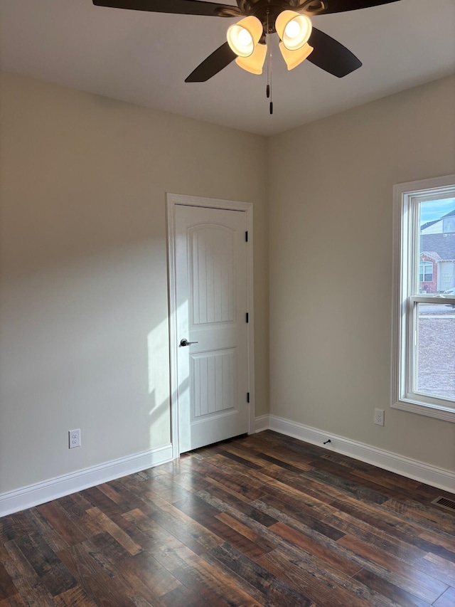 spare room featuring ceiling fan and dark wood-type flooring