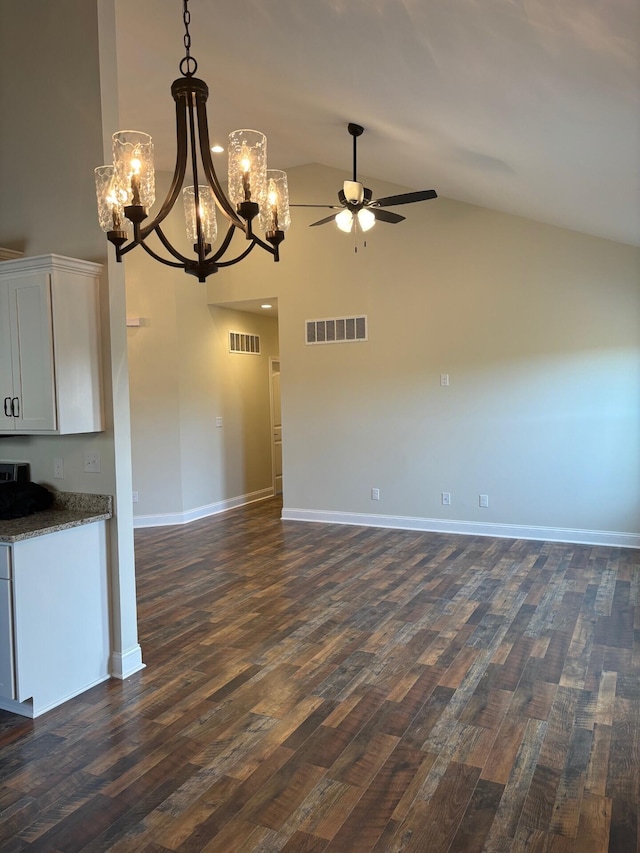 unfurnished living room featuring ceiling fan with notable chandelier, dark wood-type flooring, and lofted ceiling