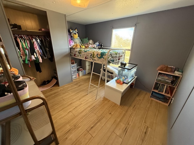 bedroom with light wood-type flooring and a closet