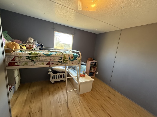 bedroom featuring light hardwood / wood-style floors and a textured ceiling