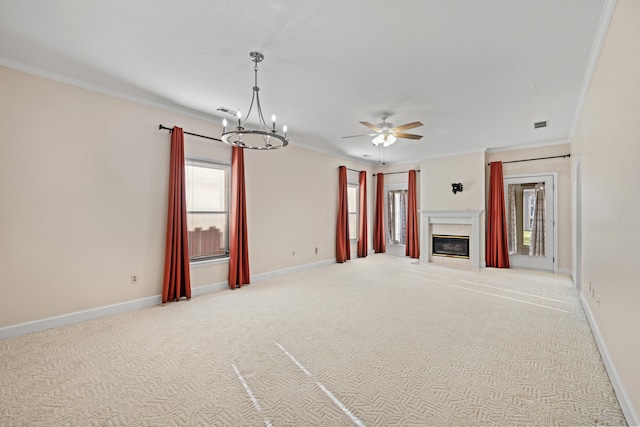 unfurnished living room with carpet, ceiling fan with notable chandelier, crown molding, and a tile fireplace