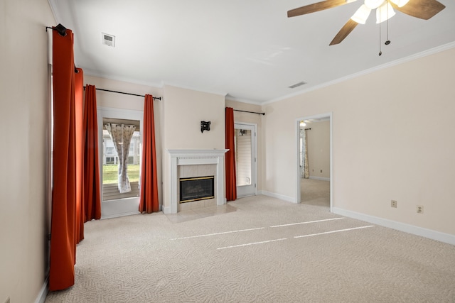 unfurnished living room featuring light carpet, ceiling fan, crown molding, and a tiled fireplace