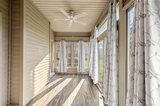 unfurnished sunroom featuring wood ceiling, a wealth of natural light, and ceiling fan