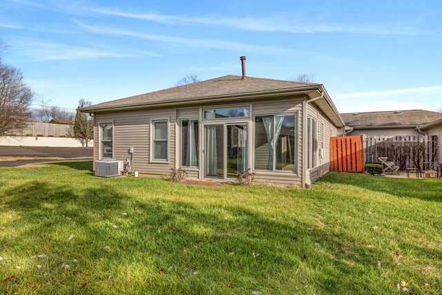 rear view of property with a lawn and central AC